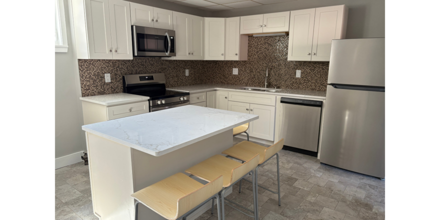 a kitchen with white cabinets and a silver refrigerator