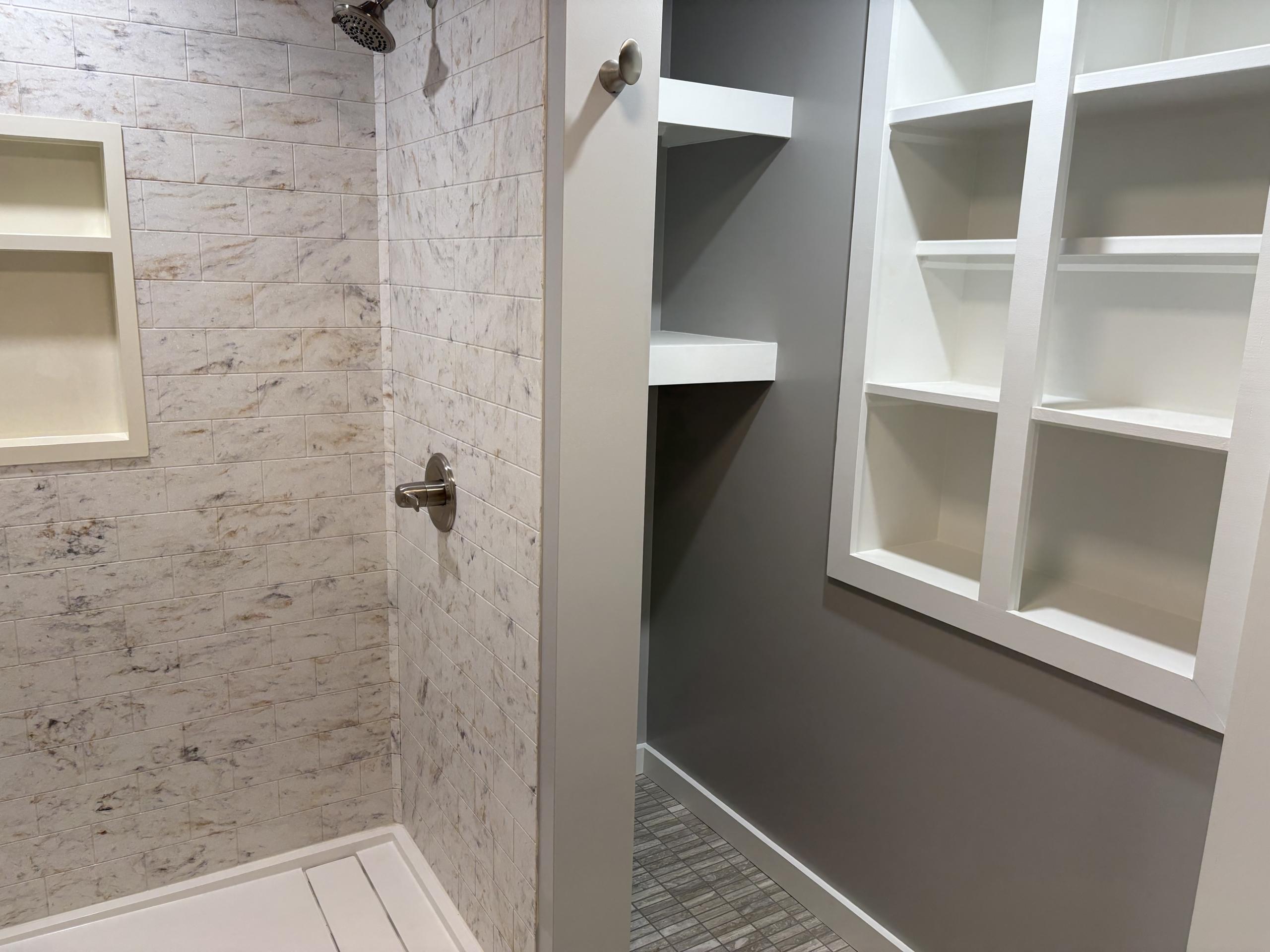 Shower and closet with white shelving