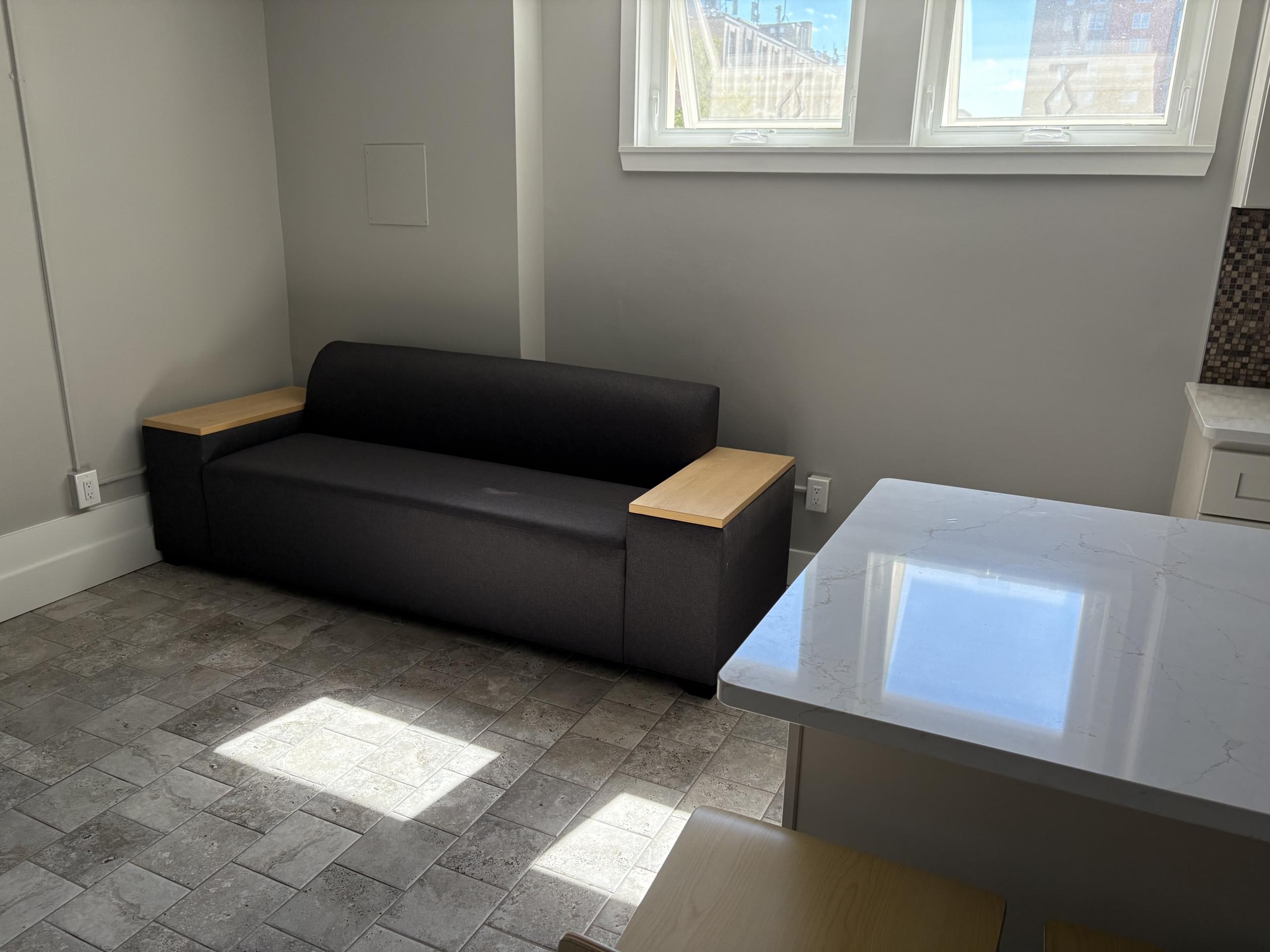 Dark sofa with wood armrests in room
