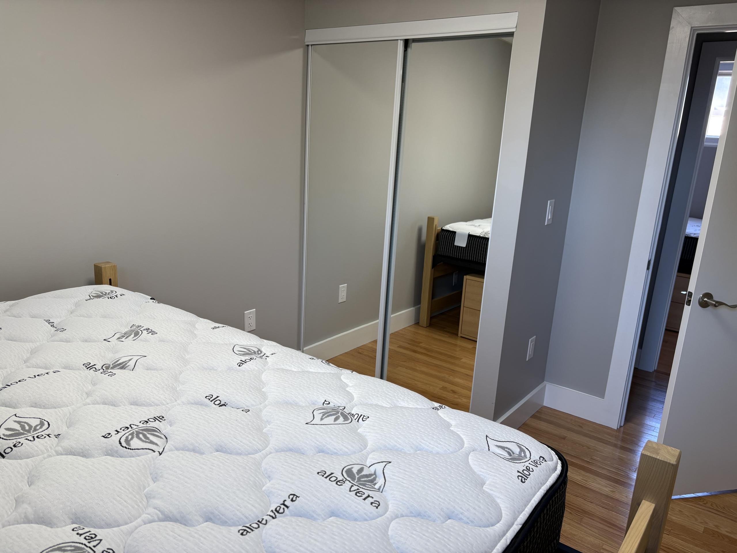 Bedroom with mattress and mirrored closet