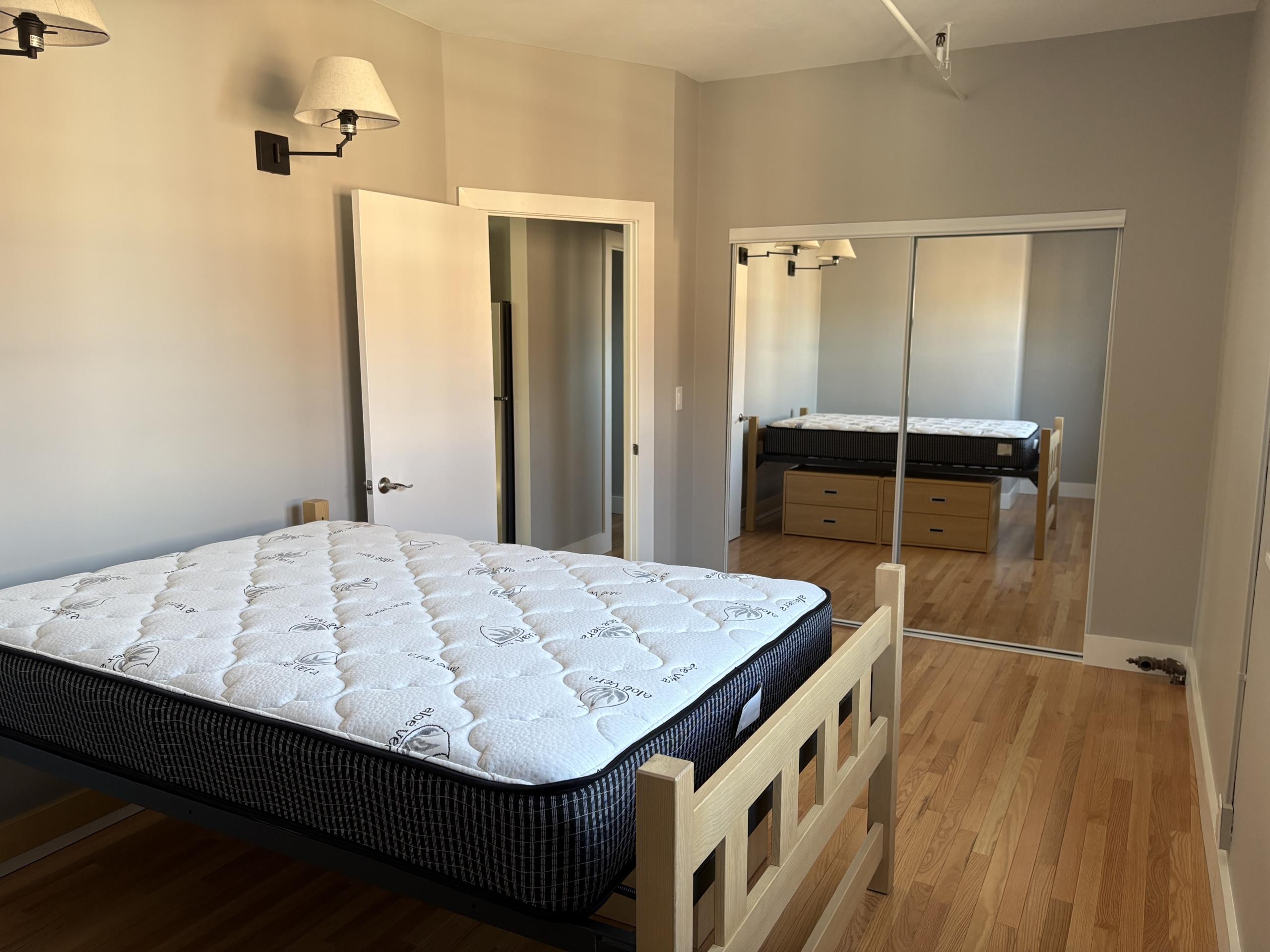 Bedroom with two beds and mirrored closet