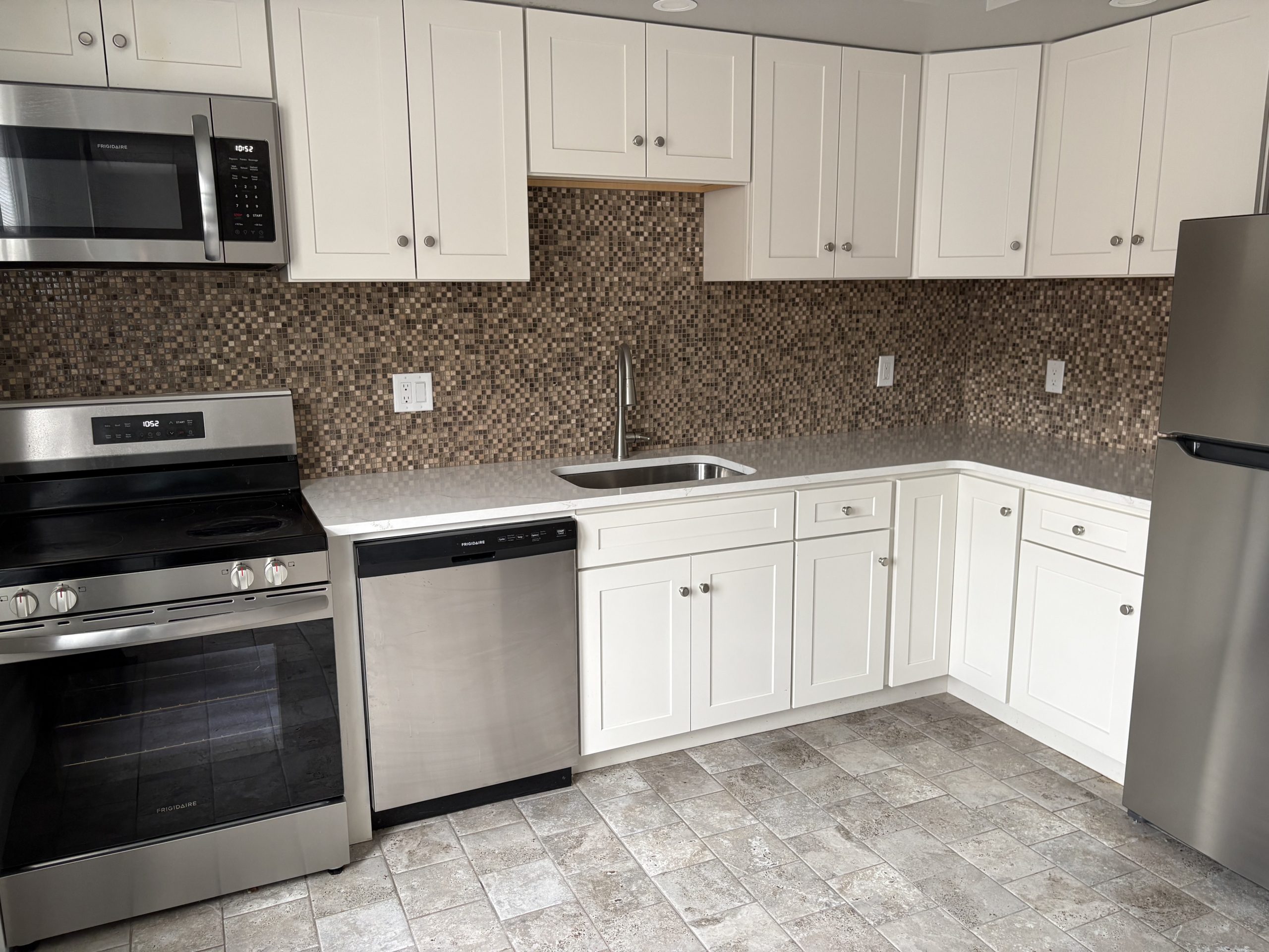 Modern kitchen with white cabinets and stainless steel appliances