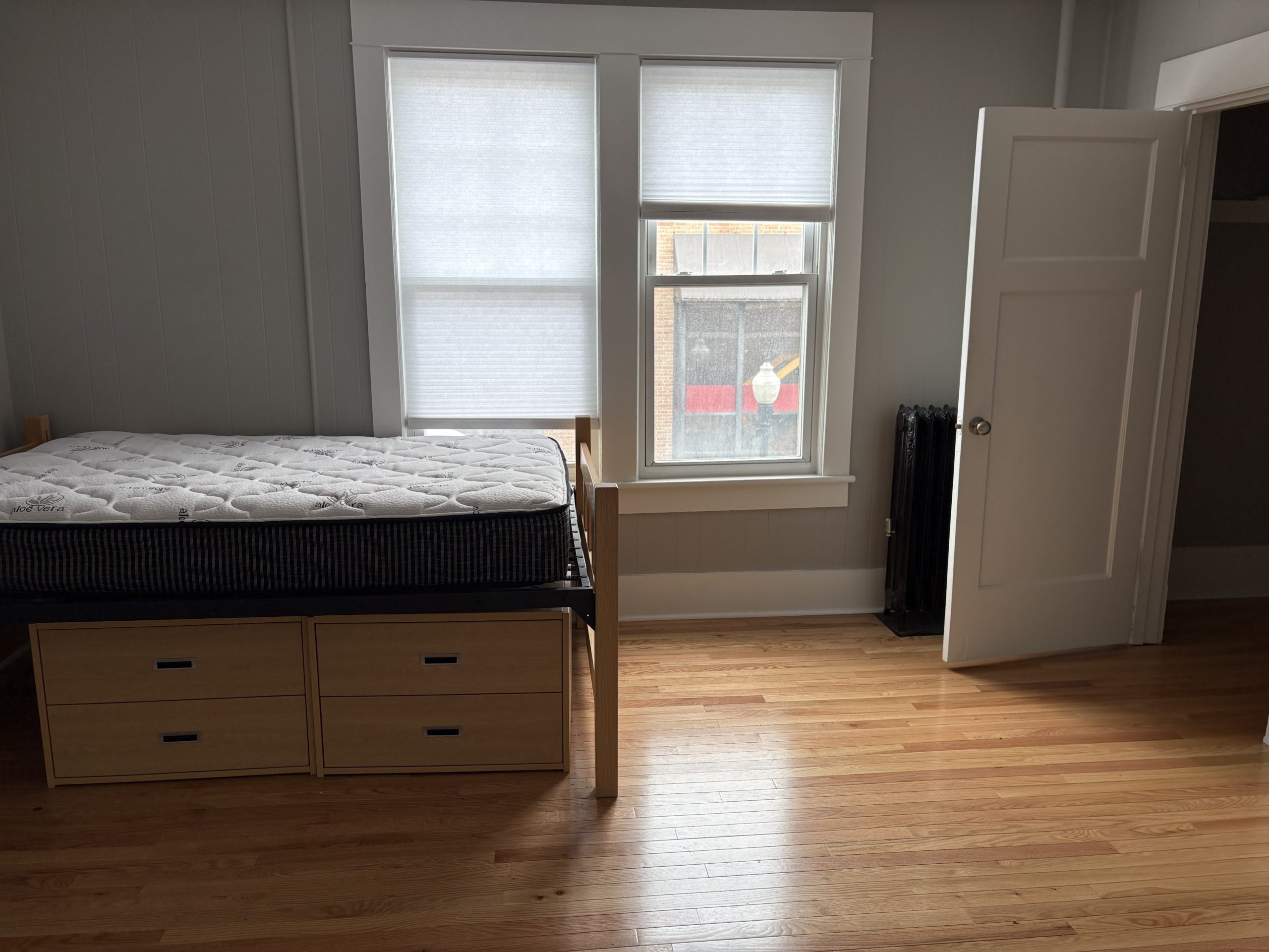 Dorm room with bed and dresser