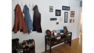 Entryway with table, pictures, and shoes.