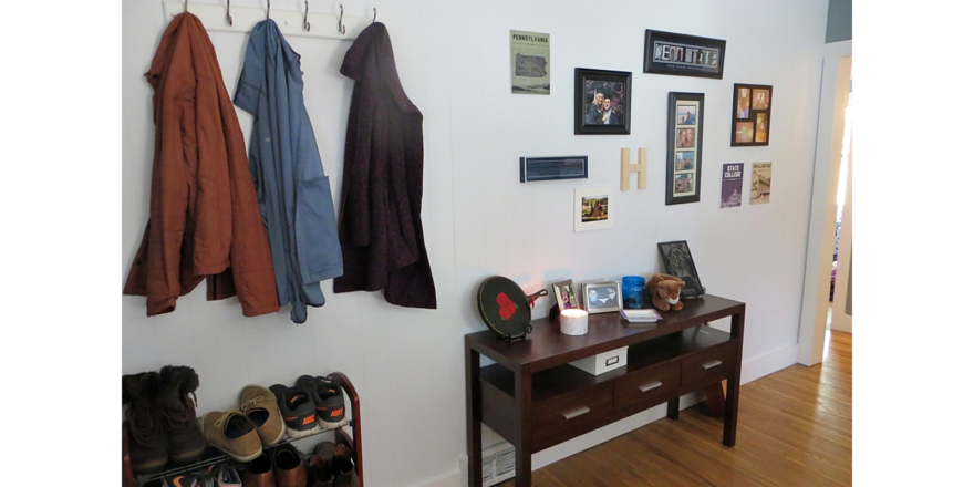 Entryway with table, pictures, and shoes.