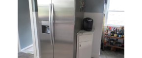 Kitchen with stainless steel fridge, small corner cabinet and bar cart