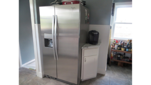 Kitchen with stainless steel fridge, small corner cabinet and bar cart