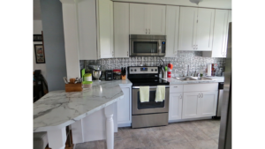 Kitchen with white cabinets, stainless steel appliances and white counter tops