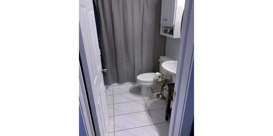 Bathroom with toilet, pedestal sink and tub/shower combo