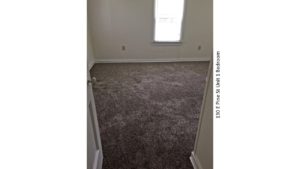 Unfurnished, carpeted bedroom with window