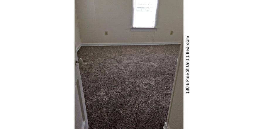 Unfurnished, carpeted bedroom with window