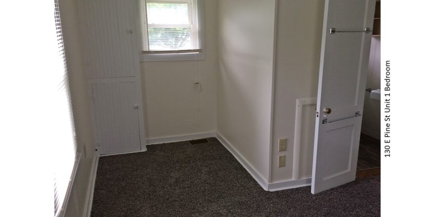 Unfurnished, carpeted bedroom with built in cabinet