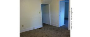 Unfurnished, carpeted living room with drop ceiling.
