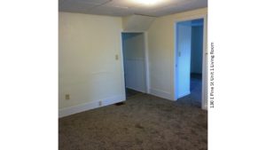 Unfurnished, carpeted living room with drop ceiling.