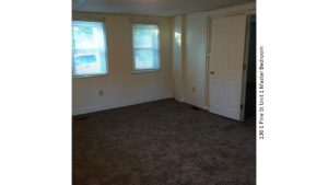 Unfurnished, carpeted bedroom with two windows