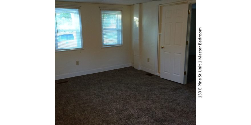 Unfurnished, carpeted bedroom with two windows