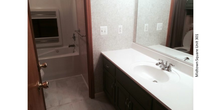 Bathroom with large vanity, tub/shower combo, and toilet