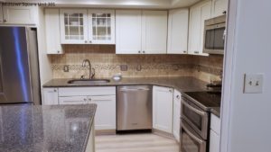 Kitchen with wood-style flooring, white cabinets, stainless steel appliances, and backsplash