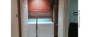 Laundry closet with washer/dryer and three cabinets above the machines