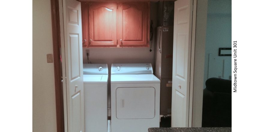 Laundry closet with washer/dryer and three cabinets above the machines