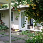 Exterior of ranch house with tan large panel siding