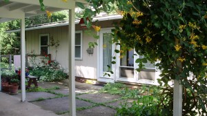 Exterior of ranch house with tan large panel siding