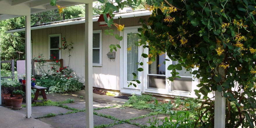 Exterior of ranch house with tan large panel siding