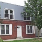 Exterior of building with red brick and vertical blue siding