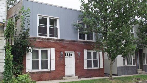 Exterior of building with red brick and vertical blue siding
