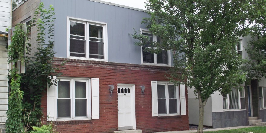 Exterior of building with red brick and vertical blue siding