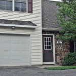 Exterior of townhouse with garage, siding, and brick exterior