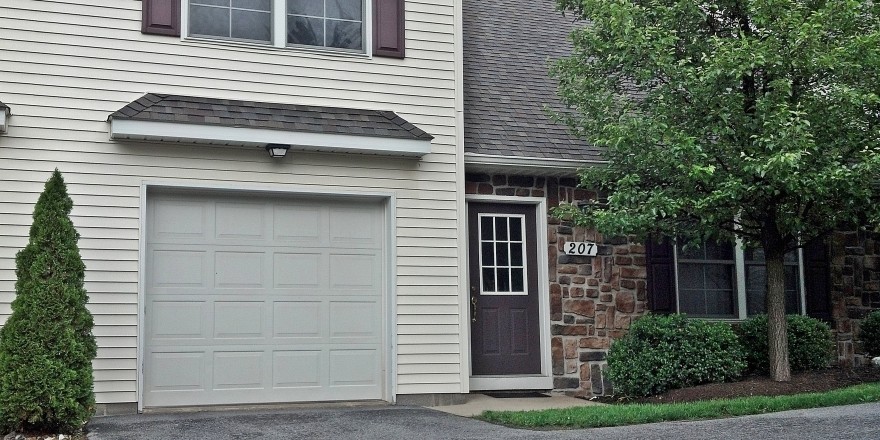 Exterior of townhouse with garage, siding, and brick exterior