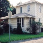 Exterior of two-story house with siding and back porch