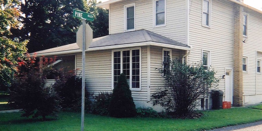 Exterior of two-story house with siding and back porch