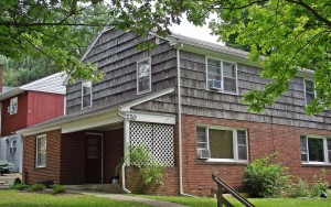 Exterior of two-story house with brick and cedar shake shingles