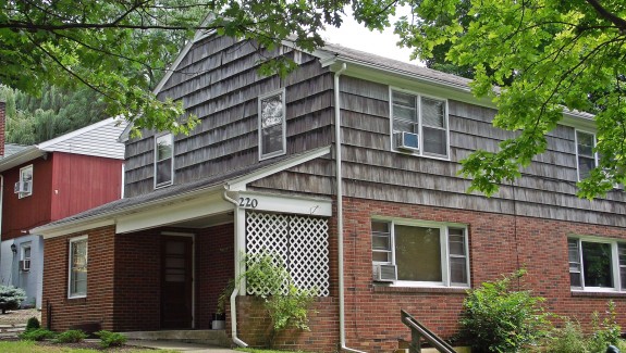 Exterior of two-story house with brick and cedar shake shingles