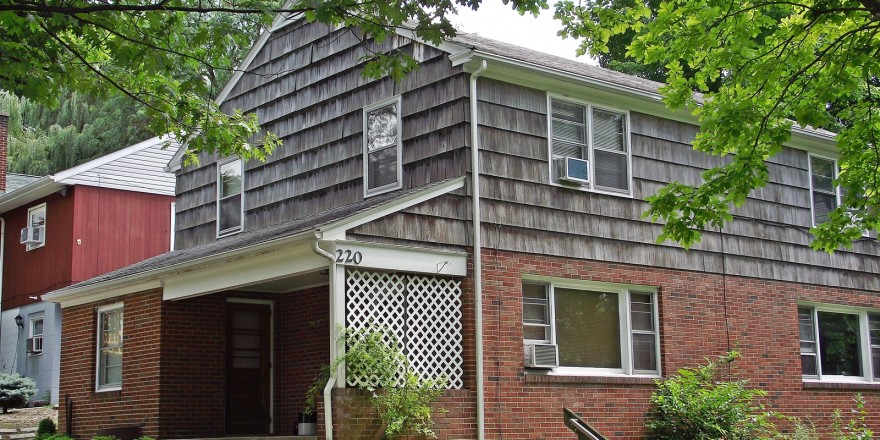 Exterior of two-story house with brick and cedar shake shingles