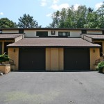 Exterior of duplex with large garage and yellow stucco siding