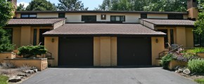 Exterior of duplex with large garage and yellow stucco siding