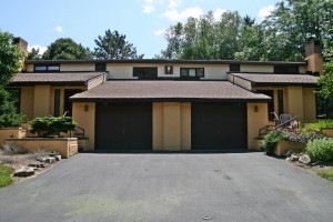 Exterior of duplex with large garage and yellow stucco siding