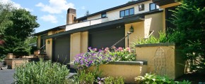 Exterior of duplex with large garage and yellow stucco siding