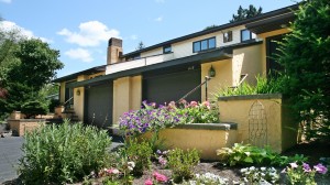 Exterior of duplex with large garage and yellow stucco siding