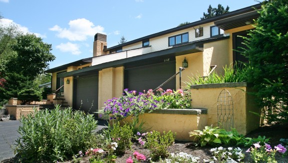 Exterior of duplex with large garage and yellow stucco siding