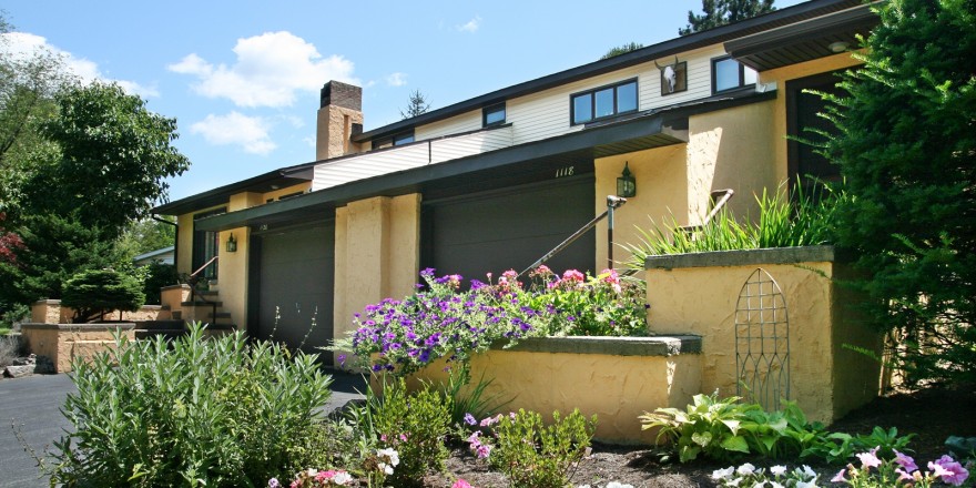 Exterior of duplex with large garage and yellow stucco siding