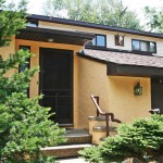 Exterior of duplex with large garage and yellow stucco siding
