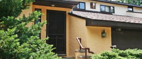 Exterior of duplex with large garage and yellow stucco siding