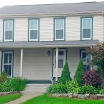 Exterior of house with tan siding and green trim