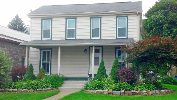 Exterior of house with tan siding and green trim