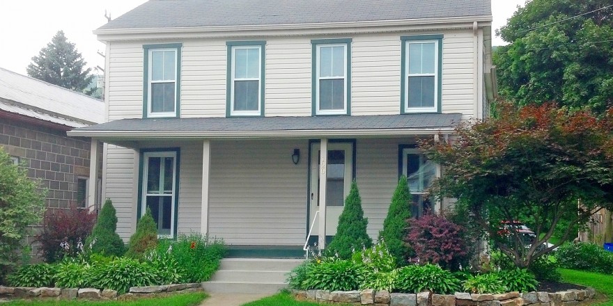 Exterior of house with tan siding and green trim