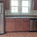 Kitchen with wood cabinets, wood-style floor and stainless steel appliances